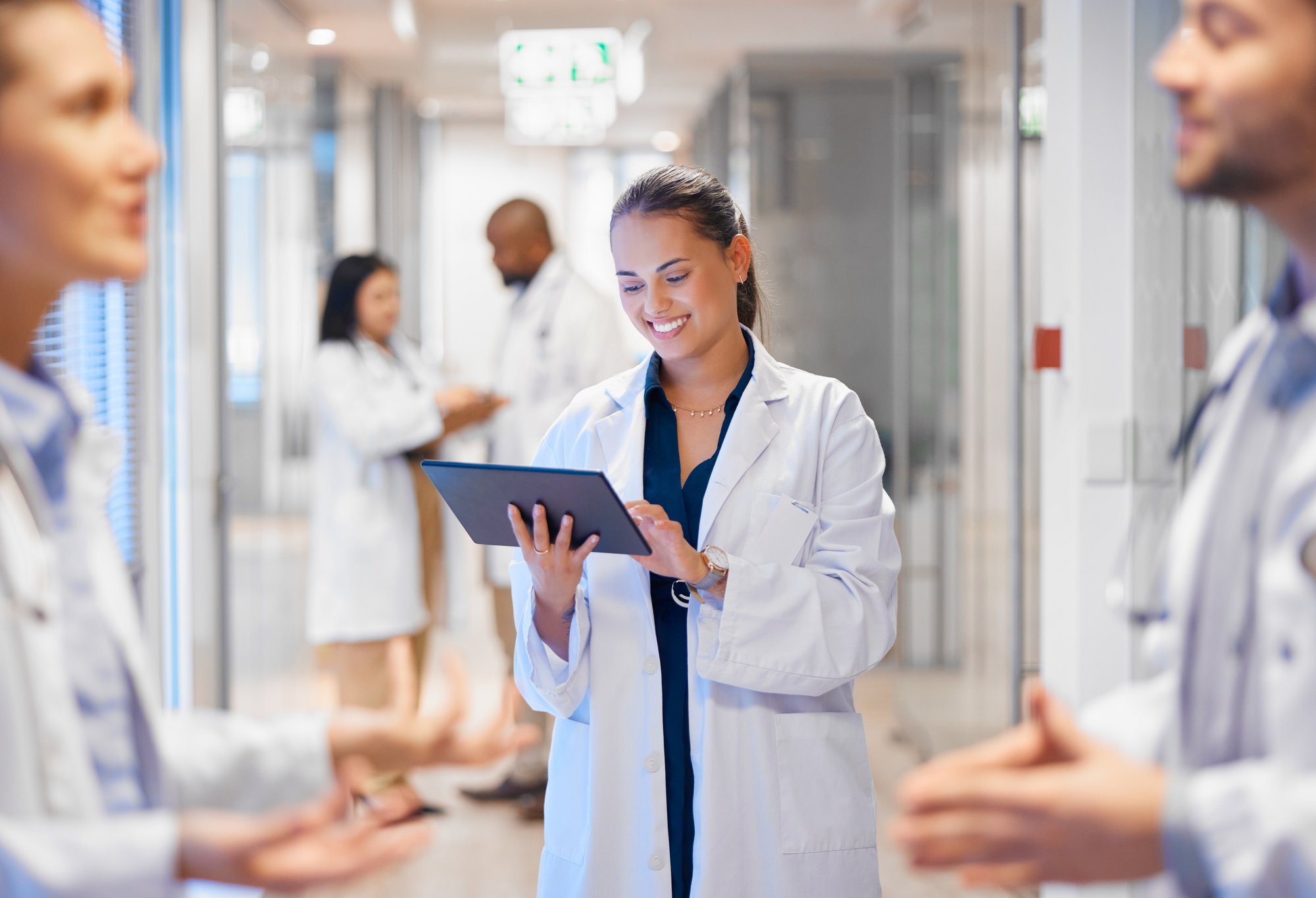 Woman in medical coat smiling at tablet Woman in medical coat smiling at tablet